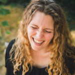 Laughing white woman with long curly light-brown hair